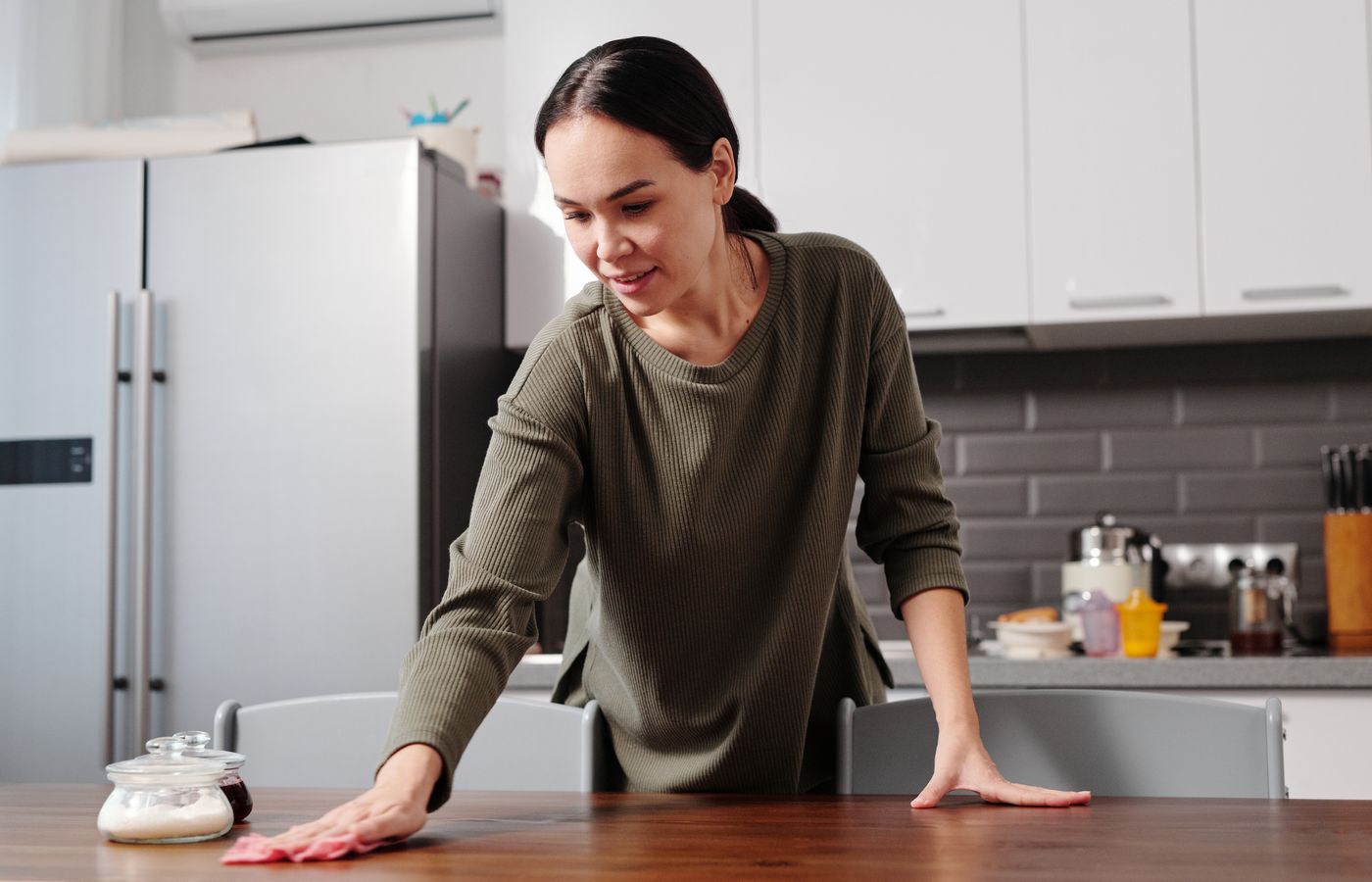 A woman wiping a kitchen table
